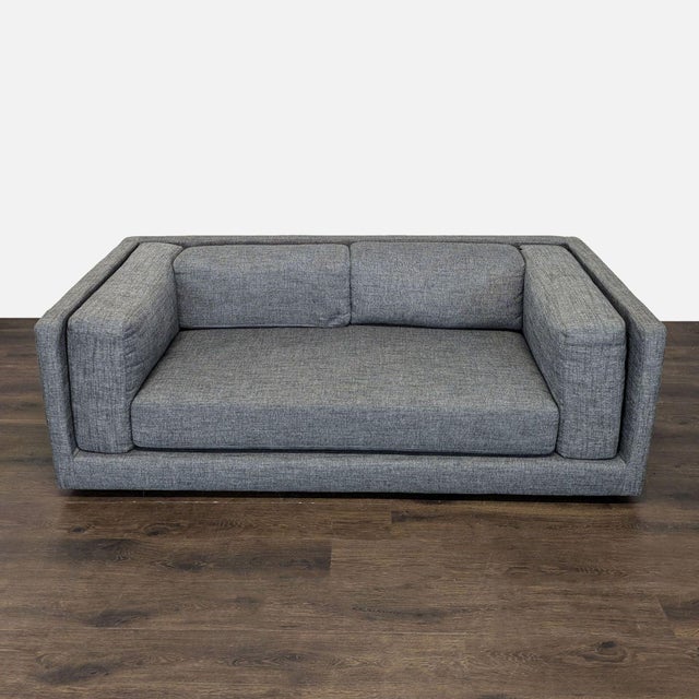This CB2 3-seat sofa features a modern, boxy design with clean lines and a stylish grey fabric. It offers a comfortable,...