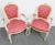 A pair of cream painted chairs with carved floral gold gilt accents, pink and gold upholstery