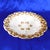 This is a white bowl with a raised relief design of vines, grapes and leaves. The leaves are painted gold, although there...