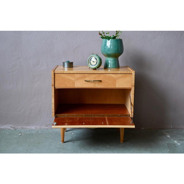 Here's a retro bedside table with simple, yet stylish compass legs. The drawer and hinged cabinet offer ample storage, and...