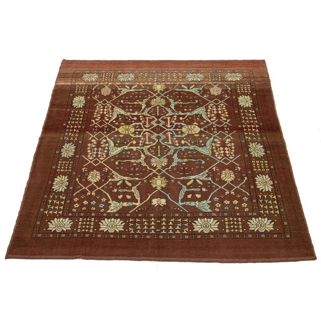 This beautiful, room-sized modern rug is hand-knotted from wool and features a brown and red base. It is part of Apadana's...