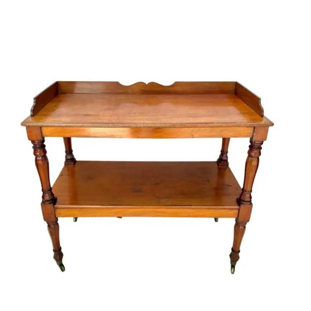 Two-Tier Walnut English Serving Trolley. Trolley features elegantly turned legs terminating in original brass casters. The...