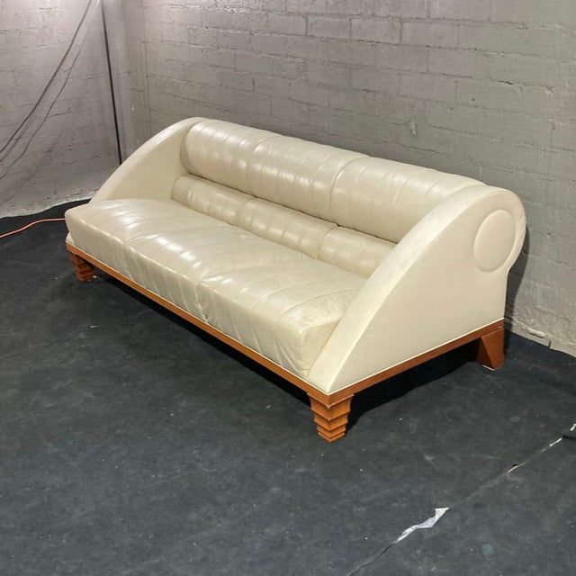 This Giorgetti 3-seat sofa features a modern design with a cream leather finish and a sturdy wooden base. It offers...