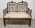 An elegant Chinese Chippendale-style settee featuring a distinctive double pagoda-form back with geometric fretwork...