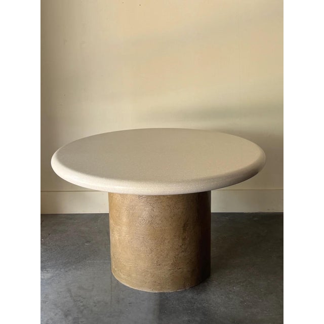 Resin and marble terrazzo round table top with textured cylindrical base. The base is made of a textured “bark” like...