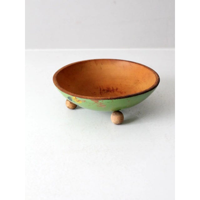 This vintage hand-painted footed wood bowl features a cheerful lime green finish with floral accents. The raised base adds...