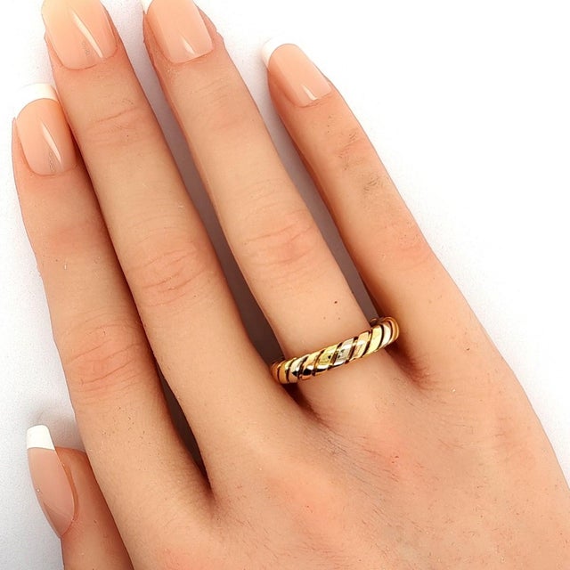 This authentic Bvlgari Tubogas band ring is crafted in solid 18k tri-color gold and features the maisons iconic Tubogas...
