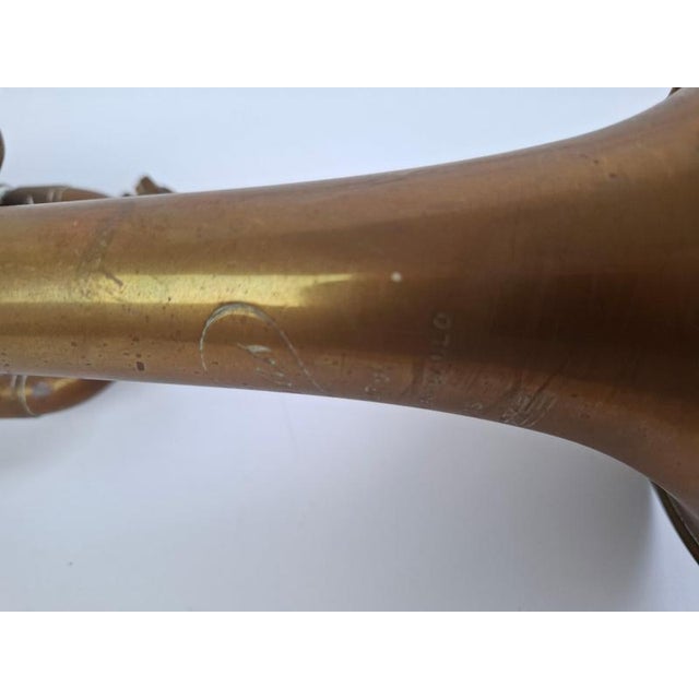 A distinctive vintage french brass instrument by j. Gras, paris, featuring an elegant elongated silhouette, a broad flared...