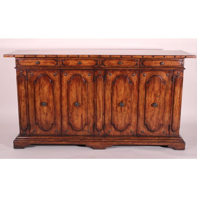 Italian baroque style hard wood credenza, late 20th century. With a rectangular top with brass studs on front and side...