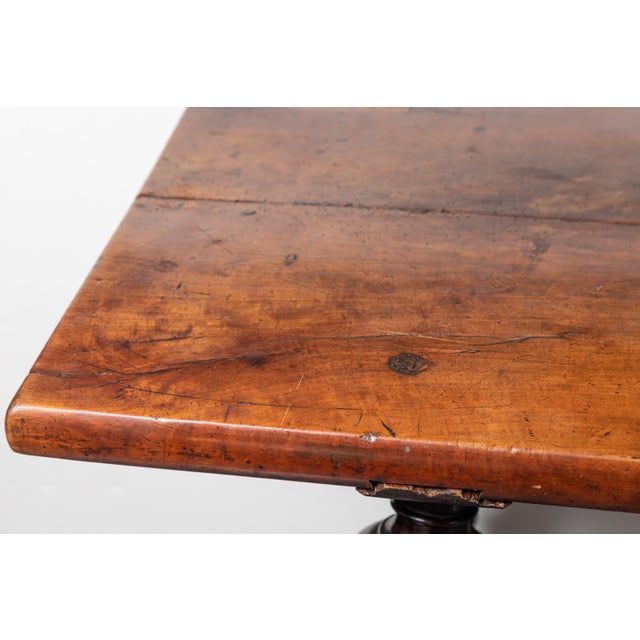 Walnut Refectory table with scrolling, hand forged, wrought iron stretcher. The two-plank top above tiered, turned legs....