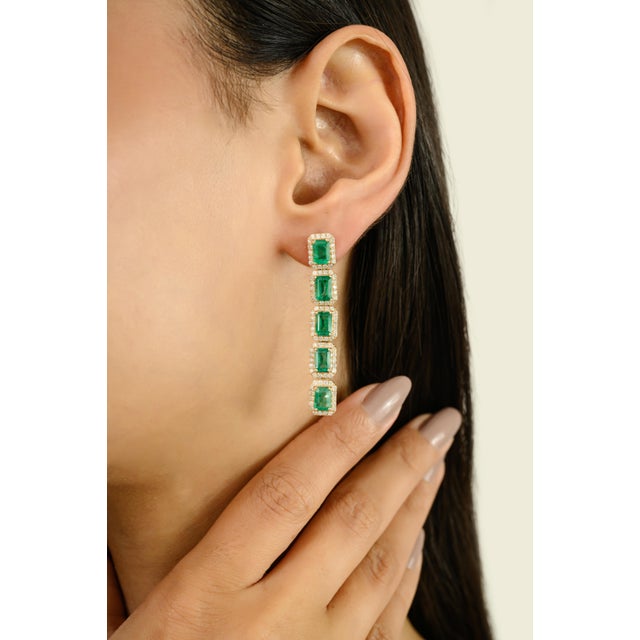 Make an unforgettable statement with these luxurious 14K Yellow Gold Emerald and Diamond Halo Dangle Earrings. Each...