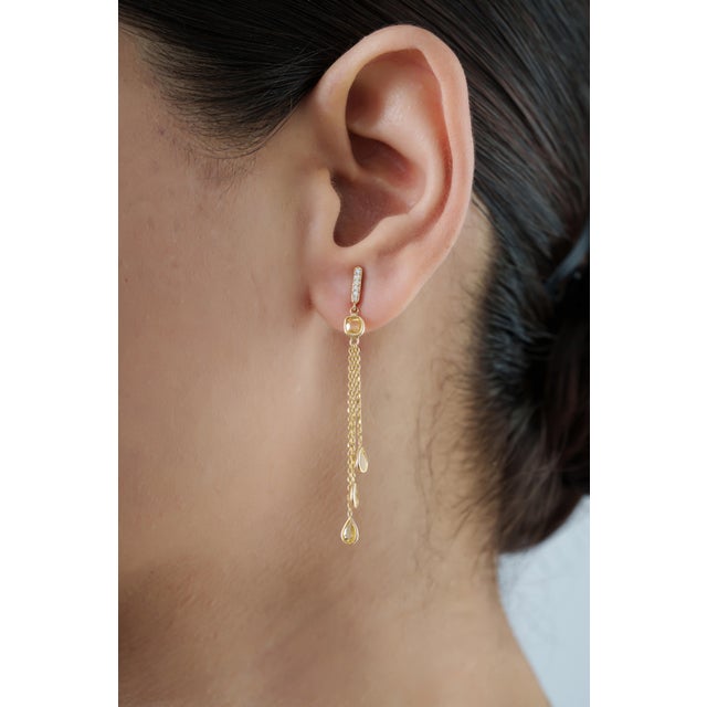 These chain drop earrings feature 1.92 carats of natural yellow sapphires, set in 14k yellow gold. The cushion-cut center...