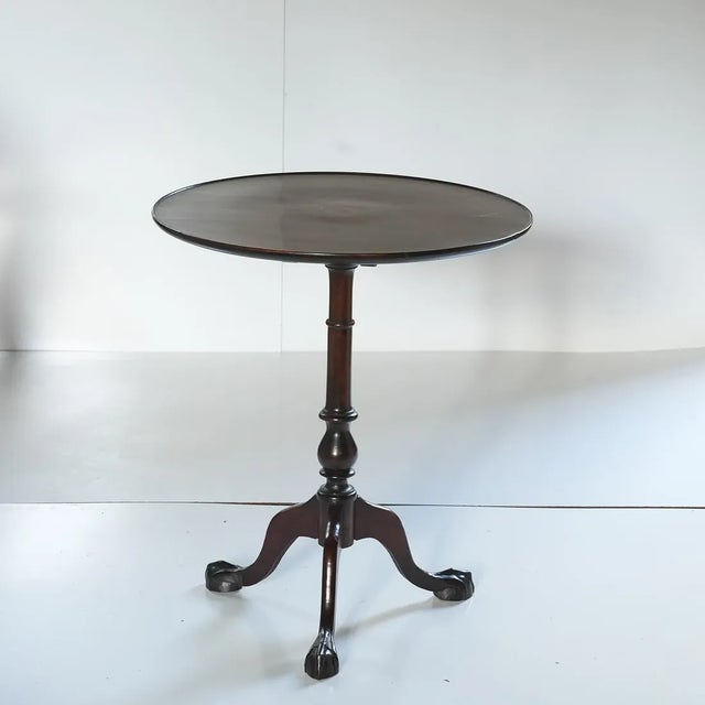 Antique English Tilt Top Tea Table with Ball and Claw Feet and a Patterae Center. The hinged round top with central inlaid...