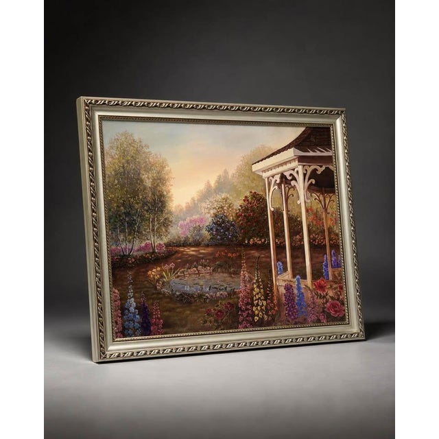 Beautiful framed garden landscape artwork featuring a gazebo, flowers, pond, trees, and warm sunset lighting. The scene...