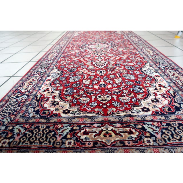 Introducing our exquisite Handmade Vintage Persian Kashan Runner, a timeless piece that hails from the 1960s and captures...