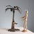 Cold-painted metal sculpture depicting an oriental man wearing a turban in the shade of a palm tree. The manufacturer's...