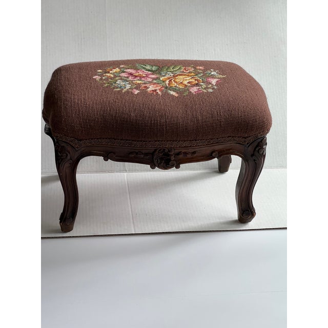 Beautiful carved vintage footstool with brown needlepoint cover with roses. Combined shipping available.