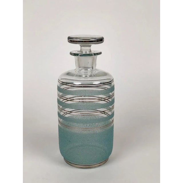 Set of three glass carafes for destilates from 1930s, made in Czechoslovakia. The carafes are decorated with silver...