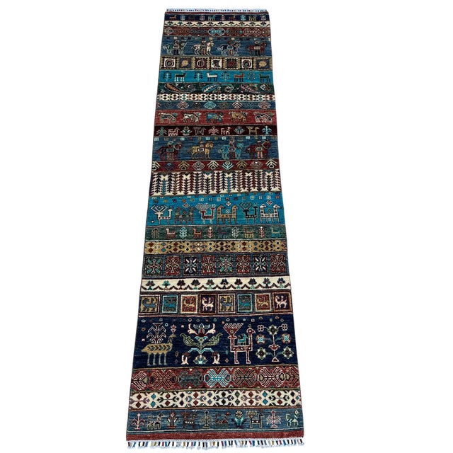 A hand-knotted pictorial runner woven in northern Afghanistan in the tribal gabbeh tradition, where the design is told in...