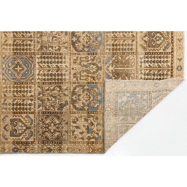 Elevate high-end interiors with this vintage hand-knotted wool area rug. Featuring a grid-paneled composition of geometric...