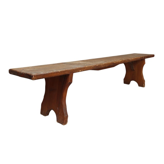 A late 19th Century long rustic bench. Handcrafted and made of pine, rich with patina. The bench has a plank wood top and...