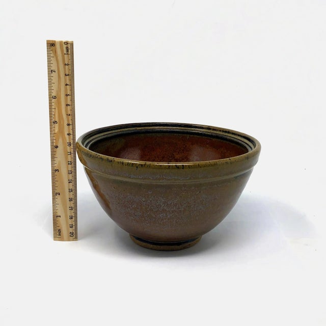 This handmade art pottery bowl features a beautiful brown glaze and is signed by the artist. Measures about 4 inches tall...