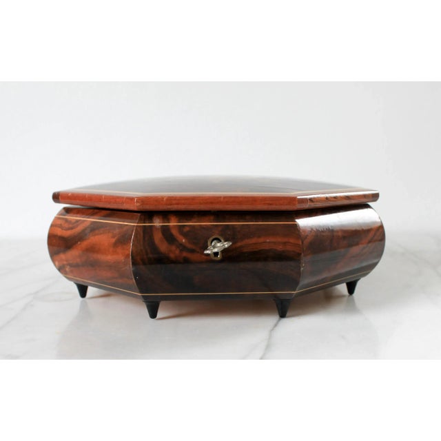 Vintage octagonal rich burlwood jewelry music box with inlaid floral motif and red velvet interior lining. Plays the song...
