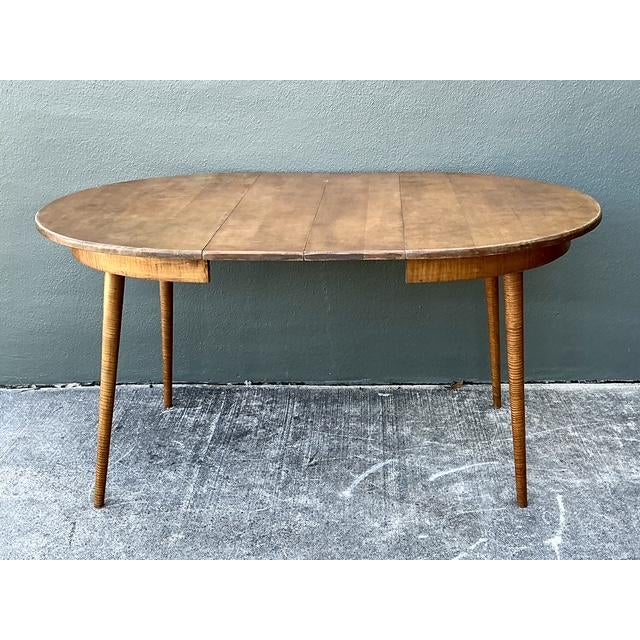 This exceptional vintage dining table is a masterclass in American woodwork, showcasing the rare and luminous beauty of...