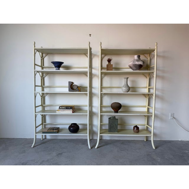 A stylish pair of vintage coastal-style étagère shelving units featuring a faux bamboo and rattan motif. These elegant...