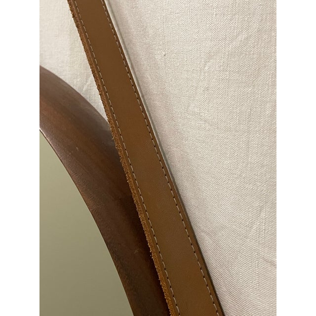 Round wall mirror from the 1980s/90s, made in Italy. The frame is made of teak wood, and it comes with a leather strap for...