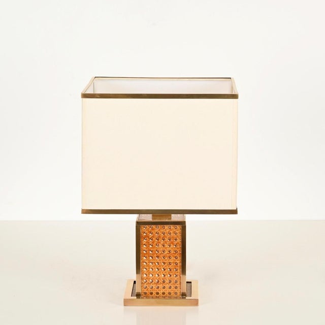 A stunning and unique italian table lamp in solid brass, acrylic, and viennese straw, complemented by an off-white and...