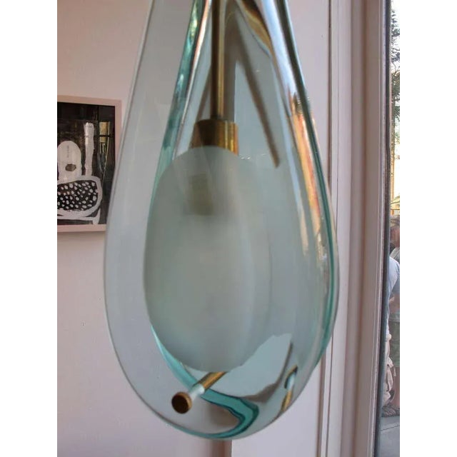 A heavy glass pendant by Max Ingrand for Fontana Arte. Heavy crystal glass and patinated brass. The glass is approx....