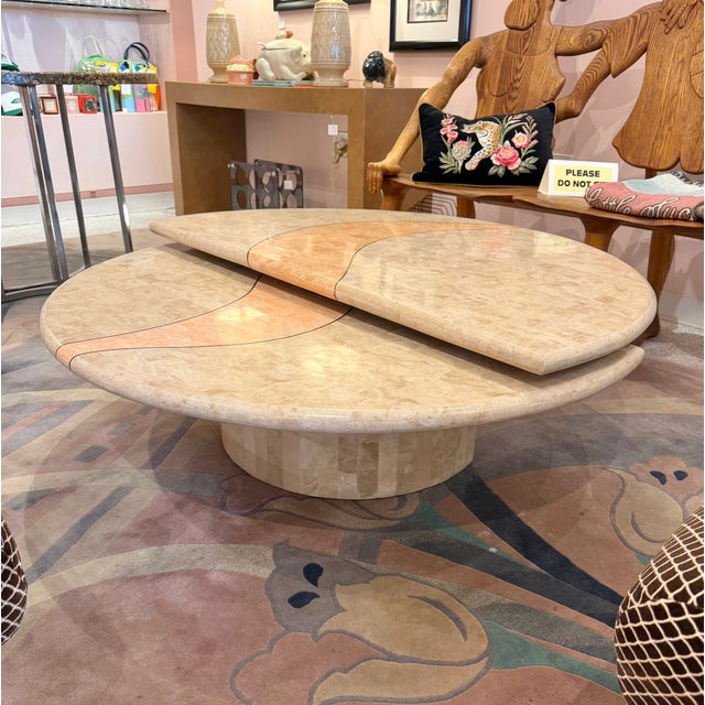 A beautiful tessellated travertine swivel coffee table by Casa Bique. The table top is a cream colored tessellated...