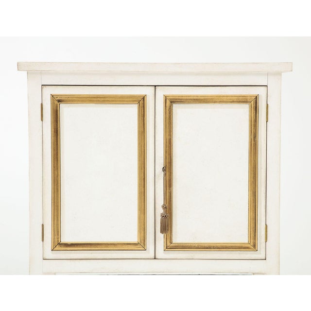 This exquisite handpainted ivory and gold Trompe l'oeil cabinet, crafted in Italy, is a stunning testament to the artistry...