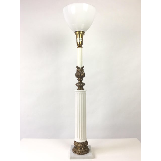 A 1950's Hollywood Regency style ceramic and brass torchiere table lamp by Thomas Industries. A white ceramic column with...