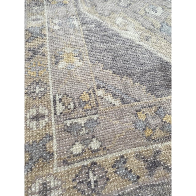 A lovely vintage Oushak runner rug. This Oushak runner offers a charcoal palette with light yellow accents.