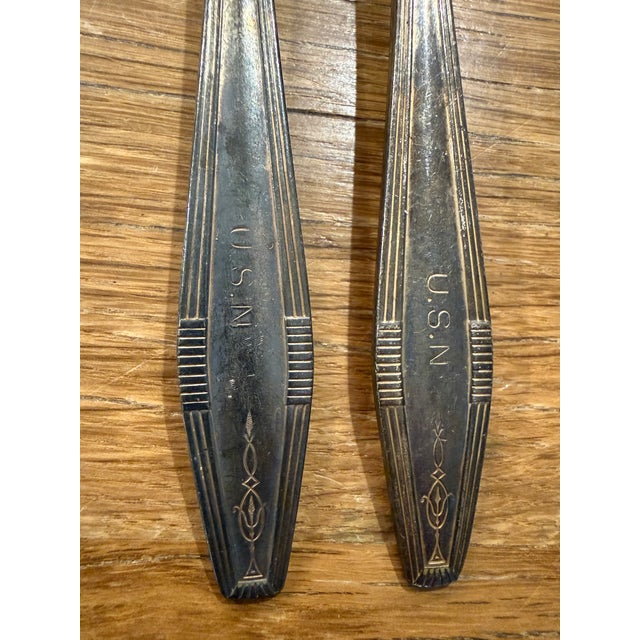 U.S. Navy (U.S.N.) silver-plated forks, which serve as highly collectible pieces of militaria. The handle bases are...
