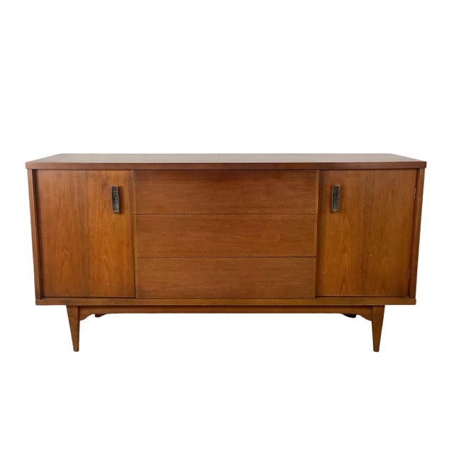 A sophisticated example of American Mid-Century Modern design, this vintage walnut credenza balances architectural...