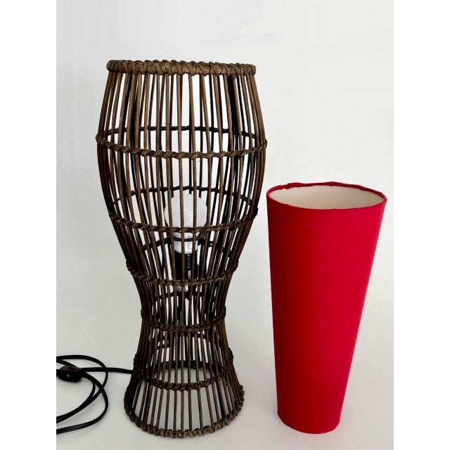 Offered is a lovely rare find rattan curvy lamp with a red deep cone shaped shade. It can be used as table lamp or on a...