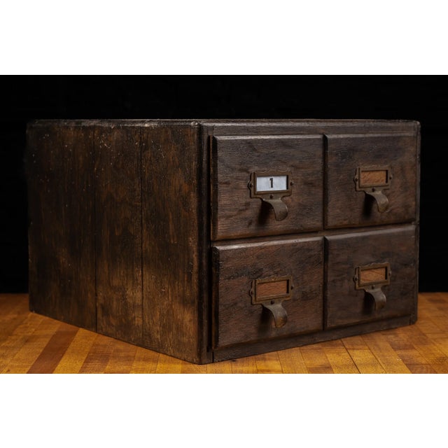 Early 20th-century solid wood card catalog cabinet featuring four deep drawers arranged in a compact two-over-two...