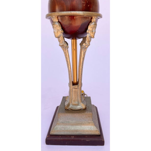 Striking Robert Abbey Art Deco Revival table lamp featuring a walnut-toned wooden globe suspended within an antiqued metal...
