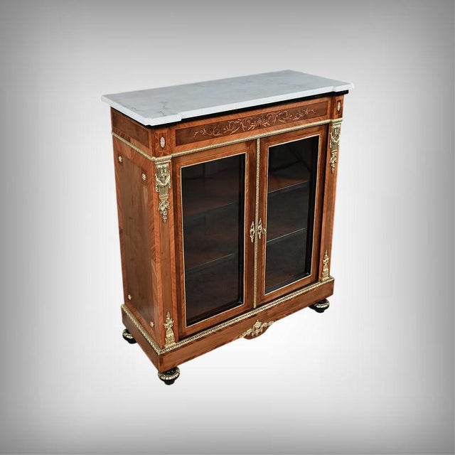 This Napoleon III display cabinet is distinguished by its elegant cherrywood structure, the warmth of its natural grain...