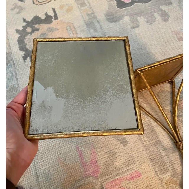 Offered is a pair of beautifully aged gold gilt style wheatgrass wall sconces. This pair features mirrored surfaces.