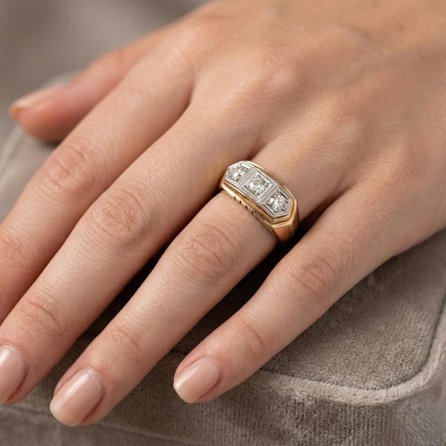 Vintage-inspired 14K yellow and white gold ring featuring three round diamonds with a total weight of 0.60 carats. The...