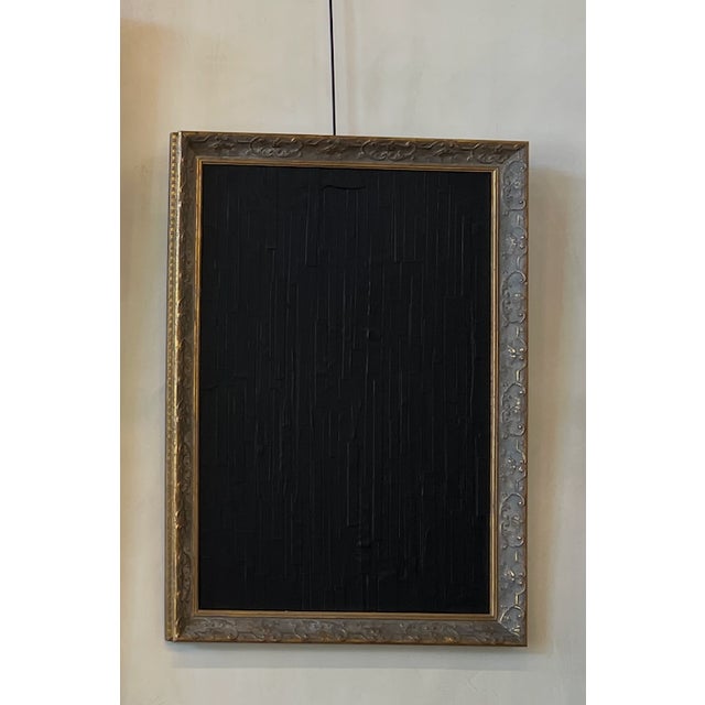 Textured black abstract artwork with vertical relief detailing, set in an ornate antique gilt wood frame. Deep matte black...