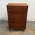 A Danish modern teak seven-drawer chest dating to the 1950s, with a tall narrow form, recessed pulls, and tapered legs....