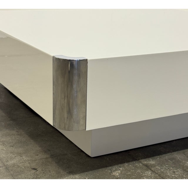 Elegant Italian coffee table attributed to Willy Rizzo, featuring a clean architectural form finished in glossy white...