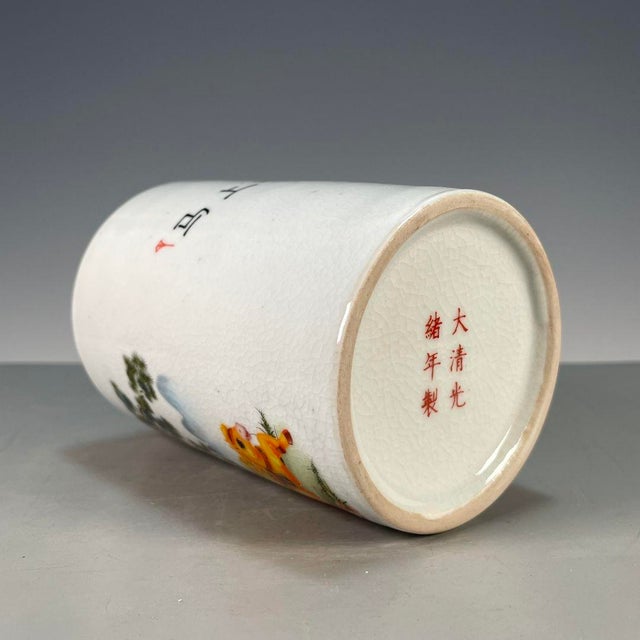 A charming Chinese porcelain brush pot (bitong). The cylindrical vessel features a creamy, all-over crackle glaze and is...