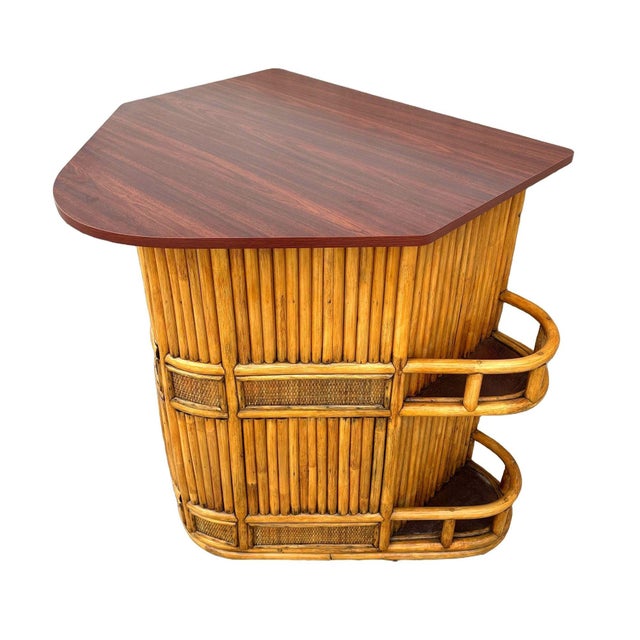 Restored dry bar showcases a distinctive stacked rattan design fashioned after the bow of a sailboat. The bar features a...