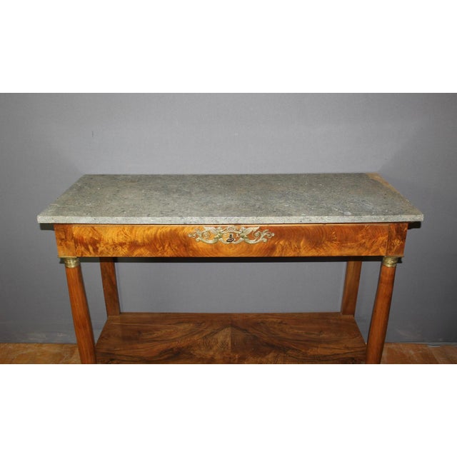 Empire period walnut console table, it opens with a drawer, original bronze columns, grey marble top, early 19th century,...